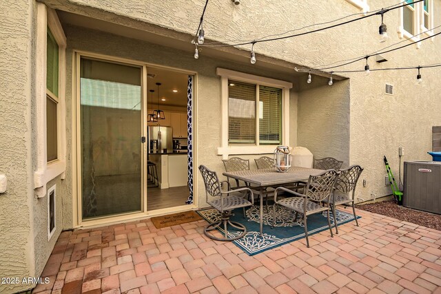 view of patio with outdoor dining area and visible vents