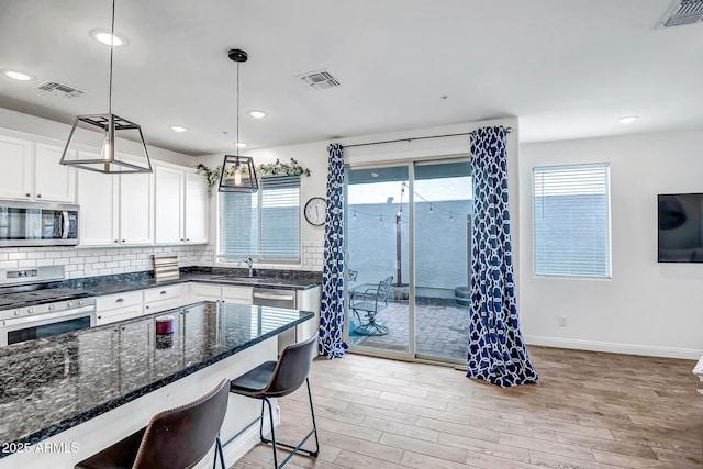 kitchen with stainless steel appliances, visible vents, and decorative backsplash