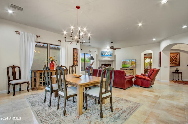 dining space with ceiling fan with notable chandelier