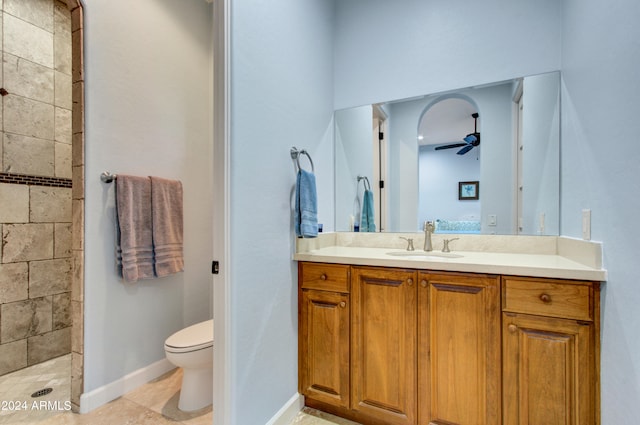 bathroom featuring tile patterned flooring, walk in shower, ceiling fan, vanity, and toilet