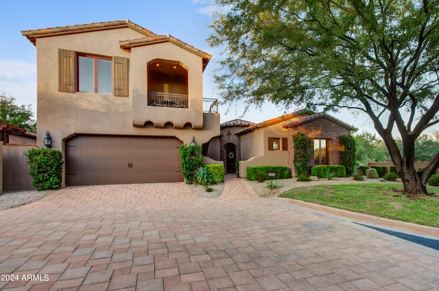 3129 S Honeysuckle Ct, Gold Canyon, AZ 85118 - mediterranean / spanish house featuring a balcony, decorative driveway, stucco siding, and an attached garage
