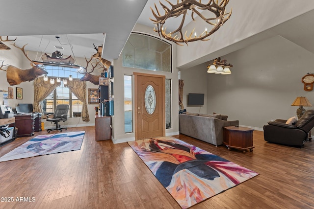 foyer featuring high vaulted ceiling, hardwood / wood-style flooring, and a notable chandelier