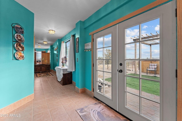 doorway to outside with light tile patterned floors and french doors