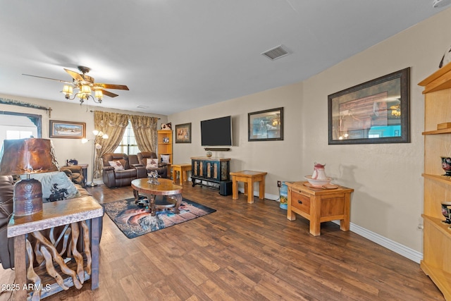 living room featuring ceiling fan and dark hardwood / wood-style floors