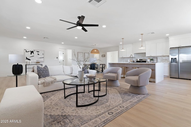 living area featuring recessed lighting, visible vents, ceiling fan, and light wood-style flooring