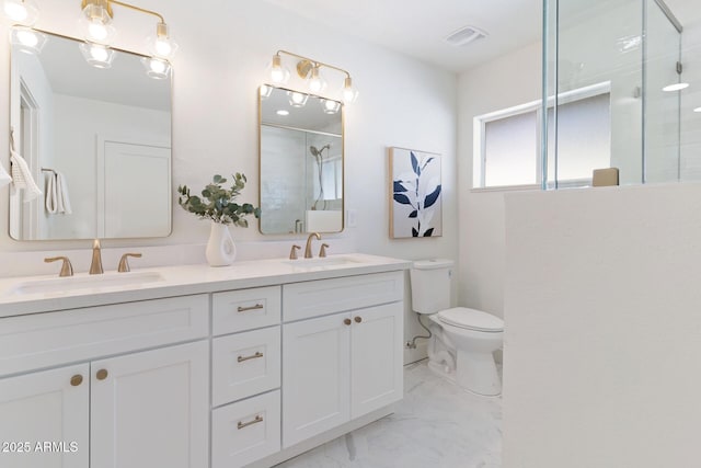 bathroom with double vanity, marble finish floor, a shower with door, and a sink