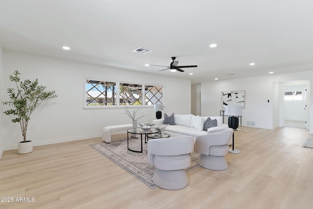 living area with light wood finished floors, visible vents, and recessed lighting