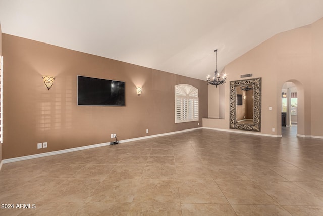 unfurnished living room with tile patterned floors, plenty of natural light, high vaulted ceiling, and an inviting chandelier