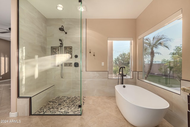 bathroom featuring separate shower and tub, ceiling fan, tile patterned floors, and tile walls