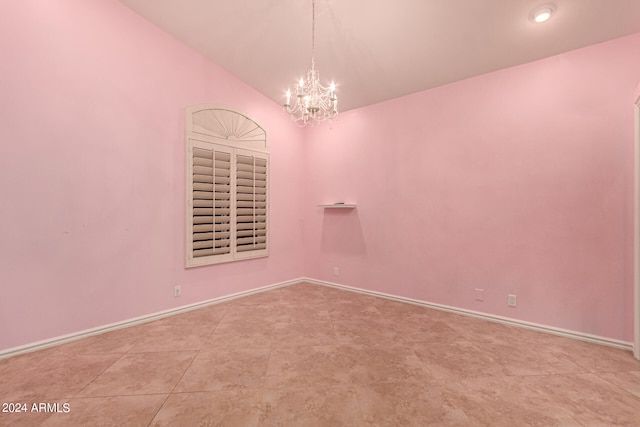 tiled spare room featuring a chandelier and lofted ceiling