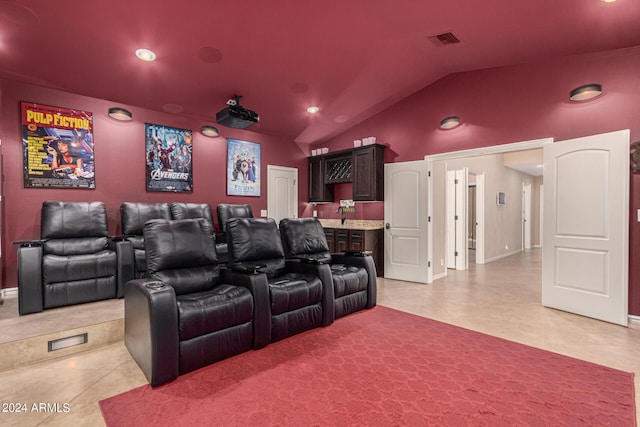 home theater with tile patterned floors, indoor wet bar, and lofted ceiling