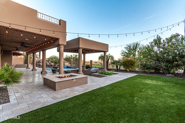 view of yard featuring an outdoor fire pit, a patio area, and ceiling fan