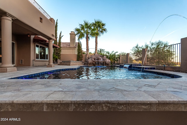 view of pool with pool water feature, a patio, and a hot tub