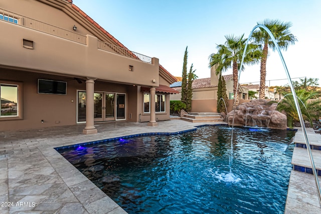 view of swimming pool featuring pool water feature and a patio