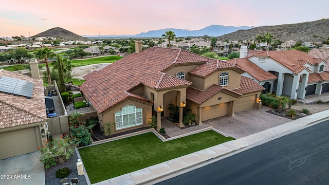 view of front facade with a lawn and a mountain view