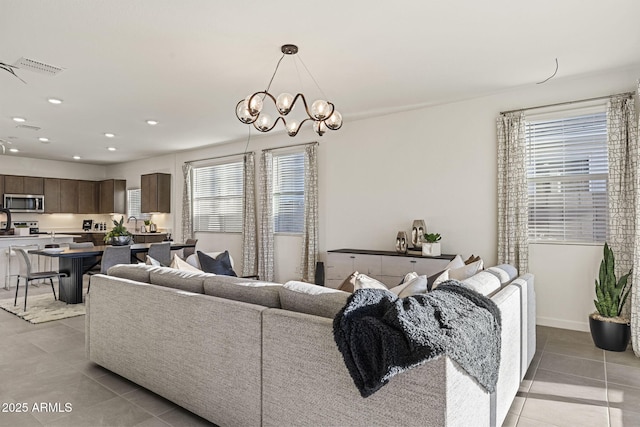 17738 W Onyx Ave, Waddell, AZ 85355 - living area featuring light tile patterned floors, healthy amount of natural light, recessed lighting, and a chandelier