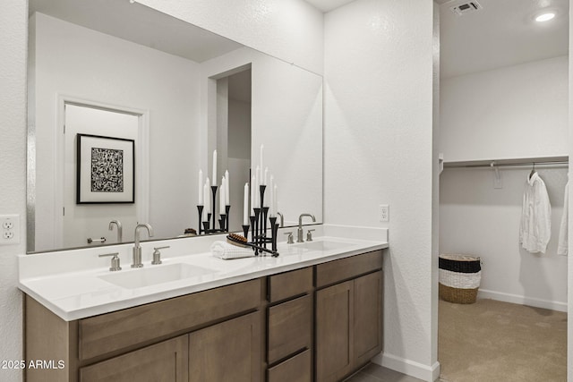17738 W Onyx Ave, Waddell, AZ 85355 - bathroom with double vanity, baseboards, and a walk in closet