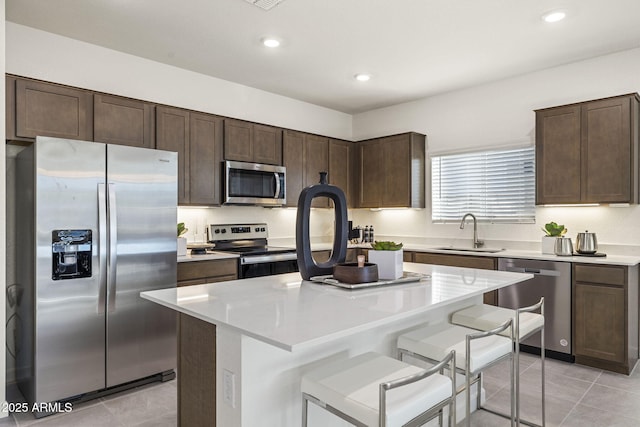 17738 W Onyx Ave, Waddell, AZ 85355 - kitchen featuring stainless steel appliances, a sink, light tile patterned floors, dark brown cabinets, and recessed lighting