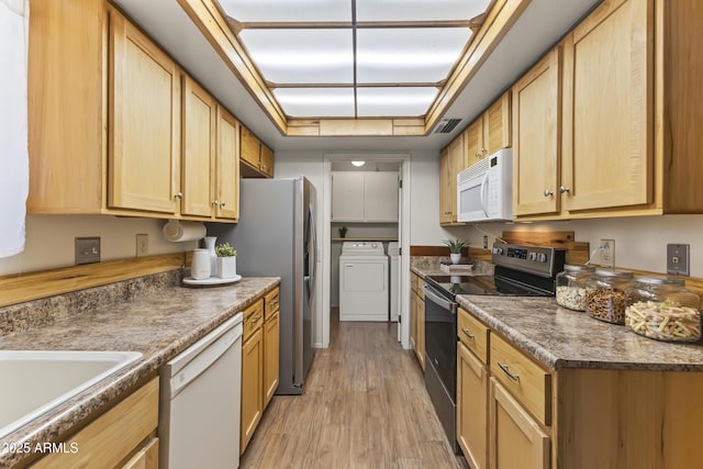 kitchen featuring independent washer and dryer, stainless steel appliances, light brown cabinets, visible vents, and light wood-style flooring