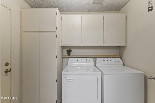 laundry area featuring a textured ceiling, visible vents, cabinet space, and washing machine and dryer
