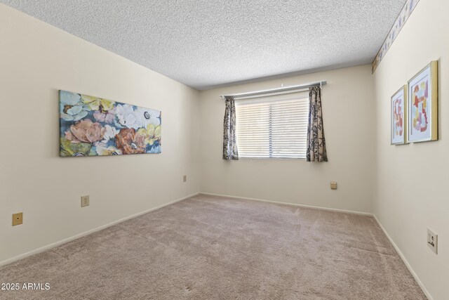 unfurnished room with a textured ceiling, carpet flooring, and baseboards