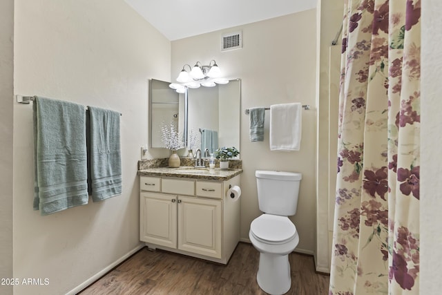 bathroom with wood finished floors, visible vents, toilet, and vanity