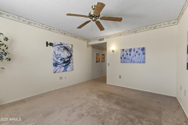 empty room featuring a textured ceiling, ceiling fan, visible vents, baseboards, and carpet