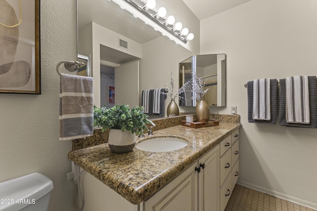 bathroom with visible vents, baseboards, toilet, tile patterned floors, and vanity