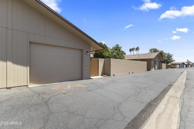 garage featuring fence and a gate