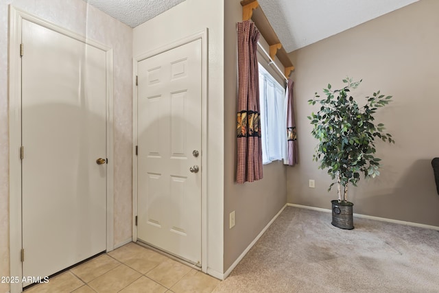 foyer featuring a textured ceiling and baseboards