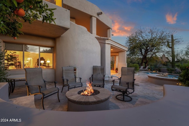 patio terrace at dusk featuring an outdoor fire pit