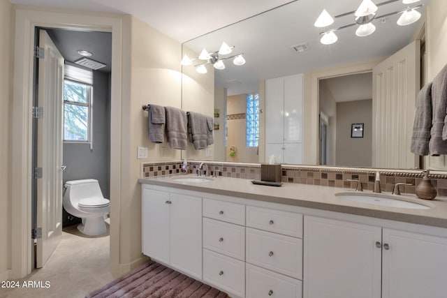 bathroom featuring tasteful backsplash, vanity, and toilet