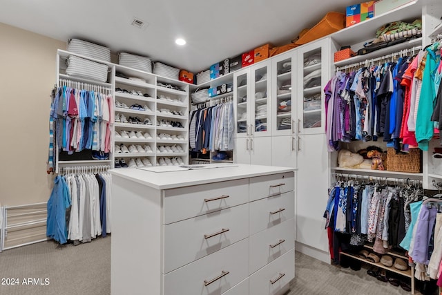 walk in closet with light colored carpet