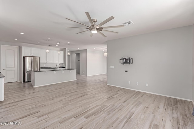 unfurnished living room with recessed lighting, a ceiling fan, light wood-style floors, and baseboards