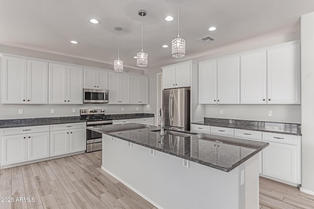 kitchen featuring light wood-style floors, recessed lighting, white cabinetry, a sink, and appliances with stainless steel finishes