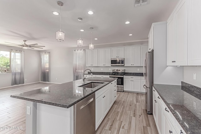 kitchen featuring visible vents, ceiling fan, white cabinetry, a sink, and stainless steel appliances