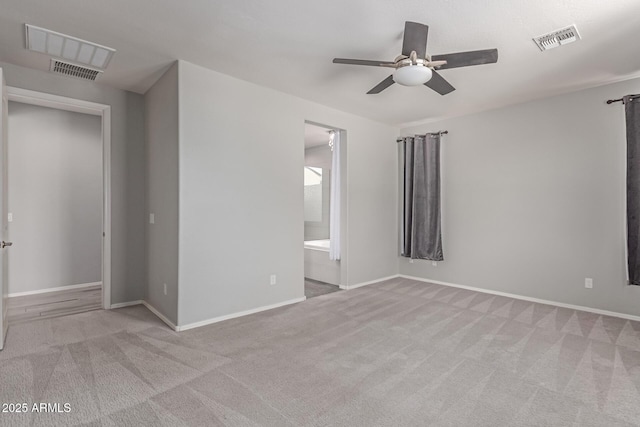 carpeted empty room with ceiling fan, visible vents, and baseboards