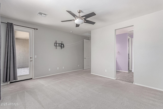 carpeted spare room with baseboards, a ceiling fan, and visible vents