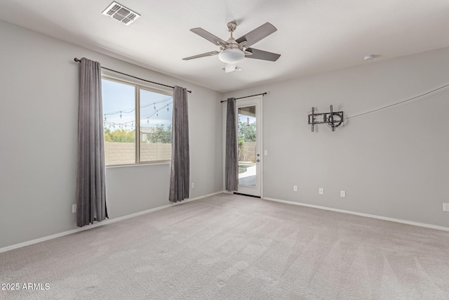 empty room with baseboards, a ceiling fan, light colored carpet, and visible vents