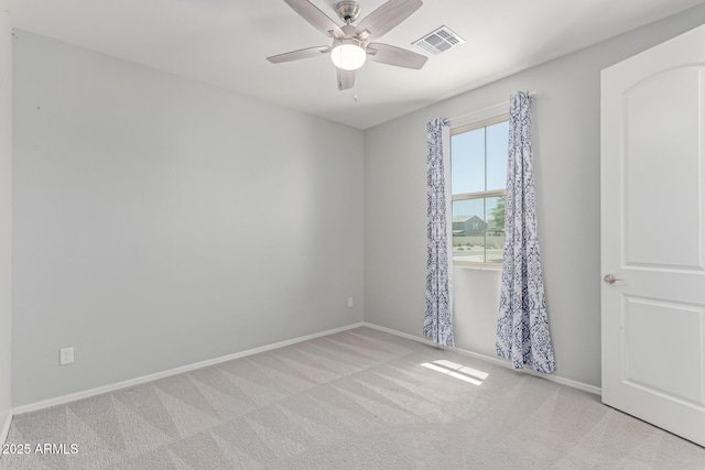 carpeted empty room featuring baseboards, a ceiling fan, and visible vents