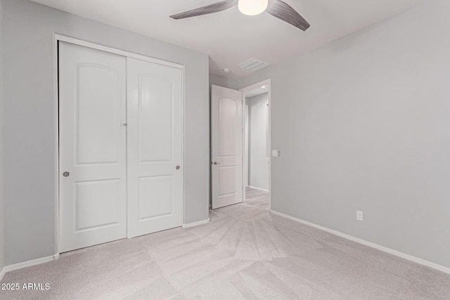 unfurnished bedroom featuring a ceiling fan, visible vents, baseboards, a closet, and carpet
