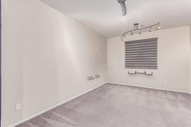 carpeted spare room featuring baseboards