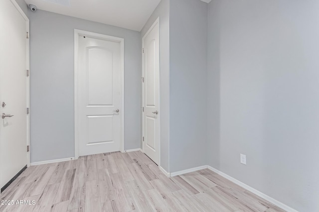interior space with baseboards and light wood finished floors