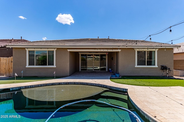back of property with a patio, fence, an outdoor pool, and stucco siding