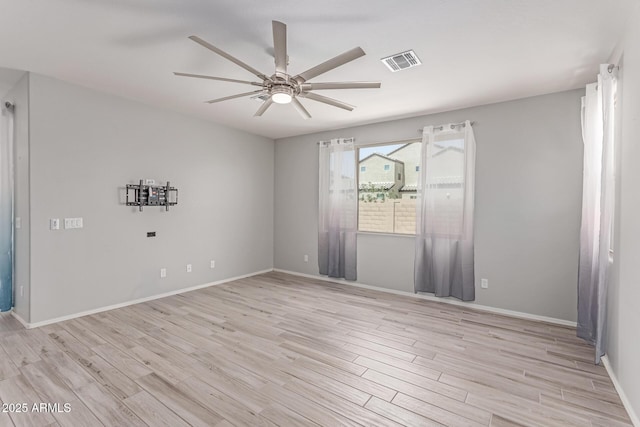 spare room with light wood-style floors, baseboards, a ceiling fan, and visible vents