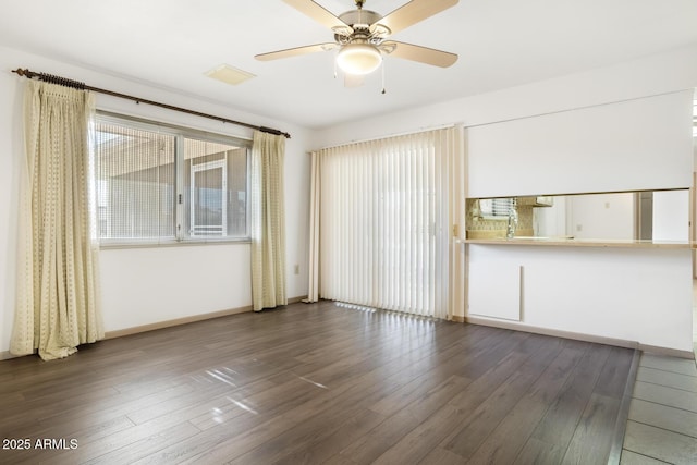 unfurnished living room with dark wood-type flooring and ceiling fan