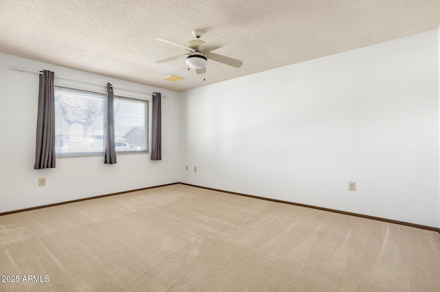 unfurnished room with ceiling fan, light colored carpet, and a textured ceiling