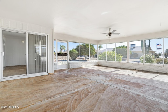 unfurnished sunroom featuring ceiling fan