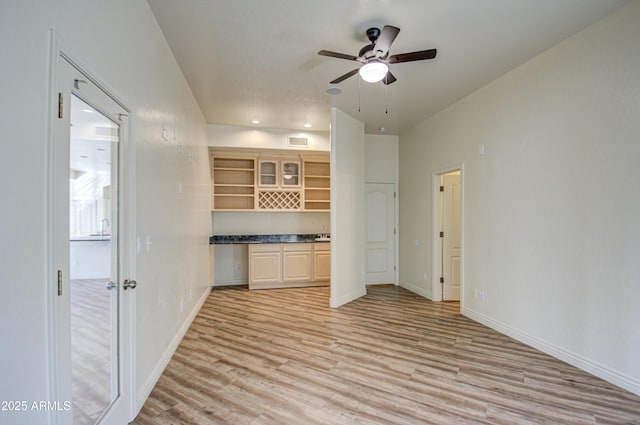 kitchen with visible vents, light wood-style flooring, open shelves, baseboards, and ceiling fan