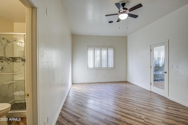 interior space with baseboards, wood finished floors, and a ceiling fan